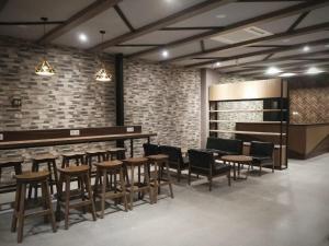 a restaurant with wooden tables and chairs and brick walls at Hotel Marina Airport Semarang in Semarang