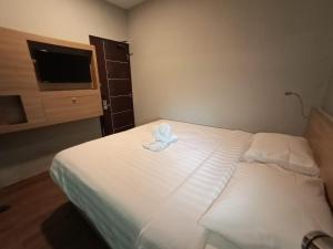 スマランにあるHotel Marina Airport Semarangのベッドルーム1室(タオル付きのベッド1台付)