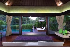 a living room with a bed and a pool at Sanctoo Suites & Villas in Sukawati