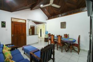 een woonkamer met een tafel en stoelen en een keuken bij Lioni Holidays Villa in Negombo
