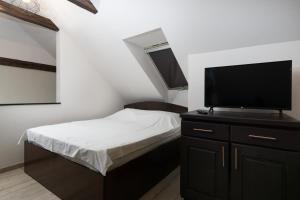 um quarto com uma cama e uma televisão de ecrã plano em House 54 em Brasov