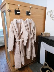 a group of towels hanging on a rack next to a fireplace at Le 43-4 avec sauna privatif in Le Puy-en-Velay