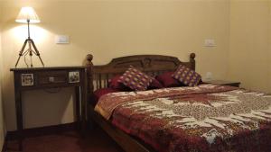 a bedroom with a bed and a lamp at Namaste Yoga Farm in Gokarna