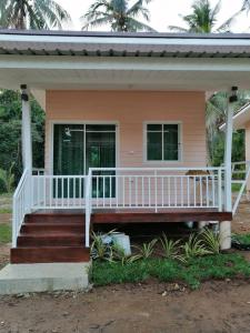 une maison avec une terrasse couverte et une balustrade blanche dans l'établissement บ้านสวนคุณตา Baan Suan Khun ta, à Ko Chang