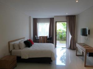 Un dormitorio con una cama y una puerta corrediza de vidrio. en Soraya Apartment Seminyak, en Seminyak