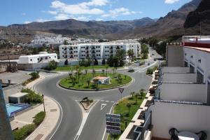 una calle vacía en una ciudad con montañas en el fondo en Hotel Puerto de Las Nieves, en Agaete