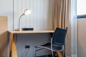 a desk with a chair and a lamp at Naga Residence in Bangkok