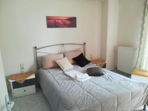 een slaapkamer met een bed met kussens erop bij 2nd Floor Apartment In Volos in Volos