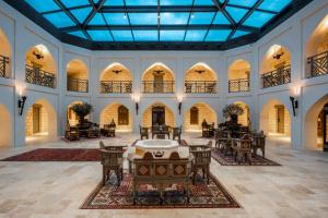 a large lobby with tables and chairs and windows at AJWA Cappadocia in Urgup