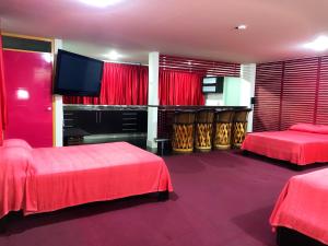 Habitación de hotel con 2 camas y TV de pantalla plana. en Palacio Rojo Hotel Familiar en Morelia