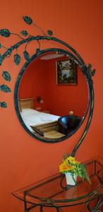 a mirror on a wall with a bed and a table at Gasthof Kaiser in Ybbs an der Donau