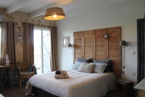 Au Pied des Baous في فونس: غرفة نوم بسرير كبير عليها دبدوب