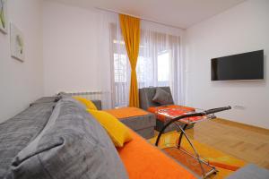 a living room with a couch and a television at Apartment Jony Lux Center in Zlatibor