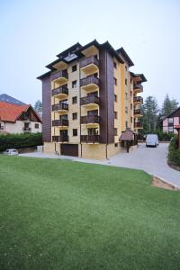 a large apartment building with a green lawn in front of it at Apartment Jony Lux Center in Zlatibor