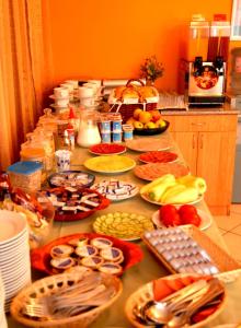 a table with many plates of food on it at Hostel Ferihegy in Vecsés