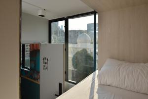 una camera da letto con un letto e una grande finestra di Atlas Hostel & Backpackers a Hong Kong