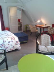 een kamer met een bed en stoelen en een tafel bij La Récré in Restigné