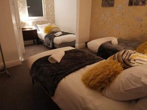 a hotel room with three beds and a desk at Corner House, Sleeps 8 in 4 Bedrooms, near train station, Great Value! in Manchester