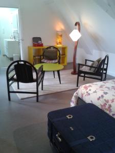 una habitación con 2 sillas y una mesa con una maleta en La Récré, en Restigné