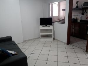 a living room with a tv on a table and a kitchen at apto na orla de Itaparica, com wifi, área privada e excelente para crianças, terceira idade e pets. in Vila Velha