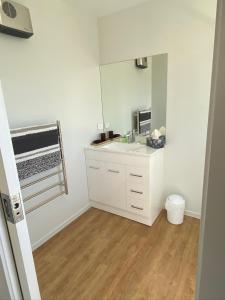 a white bathroom with a sink and a mirror at Central Retreat and self contained with free wifi in Cromwell