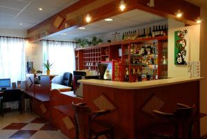 a bar in a restaurant with a counter and chairs at Hostel Ferihegy in Vecsés