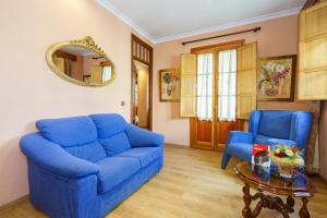 ein blaues Sofa und zwei Stühle im Wohnzimmer in der Unterkunft Hotel Los Castaños in Aracena