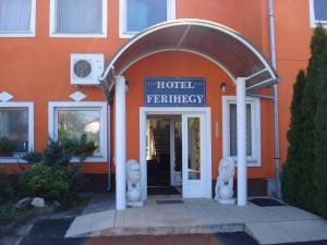 un edificio naranja con entrada a una entrada del hotel en Hostel Ferihegy, en Vecsés
