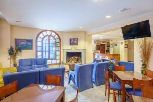 a waiting room with blue chairs and a fireplace at Hotel Los Castaños in Aracena