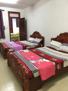três camas estão alinhadas num quarto em Nhà Nghỉ THẢO NGUYÊN XANH em Buon Ma Thuot