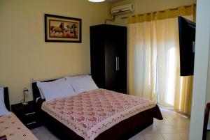een slaapkamer met een bed en een raam bij Hotel 4 Stinet in Vlorë