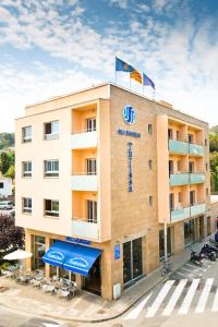 a hotel with two flags on top of it at Hotel Turissa in Tossa de Mar