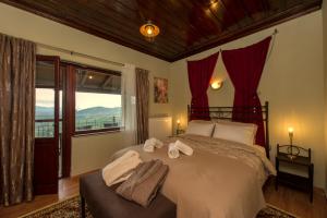 a bedroom with a large bed with towels on it at Petra Thea Villa Karitaina in Karitaina