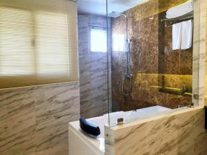 La salle de bains est pourvue d'une douche, d'un lavabo et d'une baignoire. dans l'établissement The Green View Hotel, à Ban Khlong Sanam Phli