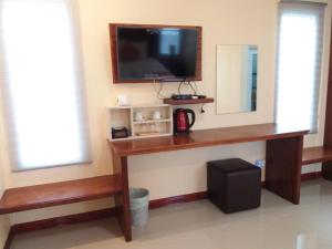 a room with a desk with a television on a wall at ฺBankunyaiy Resort in Ko Yao Yai