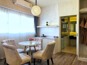 uma cozinha com mesa e cadeiras num quarto em The Green View Hotel em Ban Khlong Sanam Phli