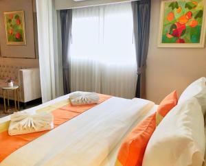 a bedroom with two beds and a window at The Green View Hotel in Ban Khlong Sanam Phli
