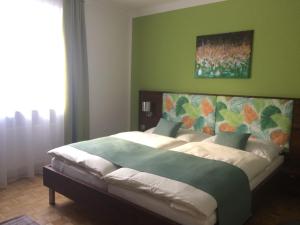 um quarto com uma cama grande e uma parede verde em Art Chic - your exklusive stay em Grödig