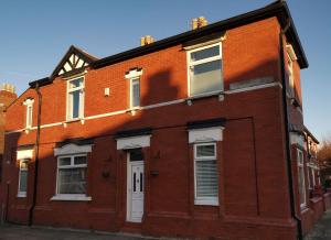 budynek z czerwonej cegły z białymi drzwiami i oknami w obiekcie Corner House, Sleeps 8 in 4 Bedrooms, near train station, Great Value! w Manchesterze