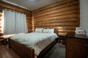 um quarto com uma cama e uma parede de madeira em 38 The Mini Cabin em Wawona