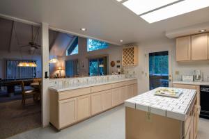 a large kitchen with white cabinets and a dining room at 43 The Last Resort in Wawona