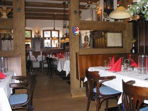 un restaurante con mesas y sillas blancas y servilletas rojas en Hotel Haus Appelberg, en Dinkelsbühl
