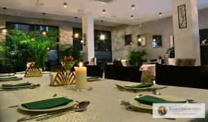 stół z zielonymi serwetkami i świecą w restauracji w obiekcie Willa Czarnieckiego w mieście Warka