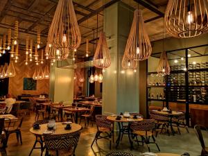un restaurant avec des tables, des chaises et des lustres dans l'établissement Asilia Suites Knysna Waterfront, à Knysna