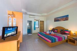 a bedroom with a bed and a flat screen tv at Grand View in Patong Beach
