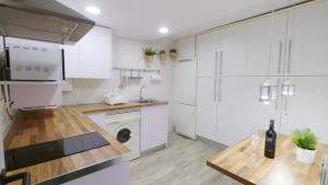 グラナダにあるApart BLANCO para ESQUÍ y ALHAMBRA. Garaje privadoの白いキャビネット、シンク、食器洗い機付きのキッチンが備わります。