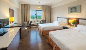 Habitación de hotel con 2 camas y escritorio en Crystal Crown Hotel Kuala Lumpur en Kuala Lumpur