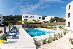 a villa with a swimming pool and a building at Petra's Place - Sea view apartment in Slatine
