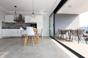 a kitchen and dining room with a table and chairs at Petra's Place - Sea view apartment in Slatine