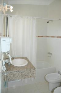 a bathroom with a sink and a toilet and a tub at Alma Marina in Valeria del Mar